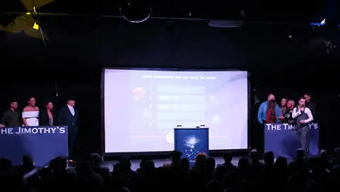 Two teams on stage for a game show during their corporate activity.