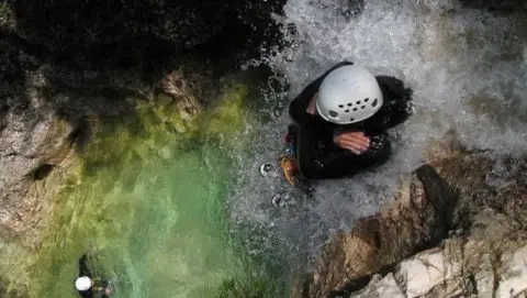 A person on a waterfall during their adventure holidays in France