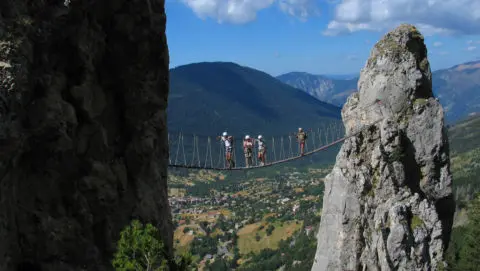People crossing a rope bridge during their Via Ferrata adventure holiday in France