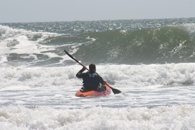 A person kayaking towards the waves