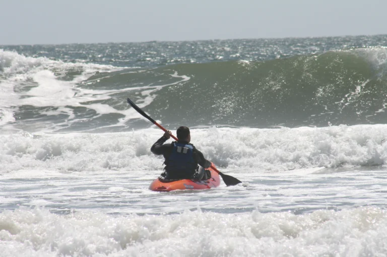 A person kayaking towards the waves