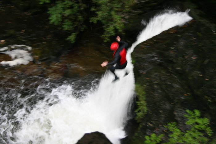 person jumping in a waterfall