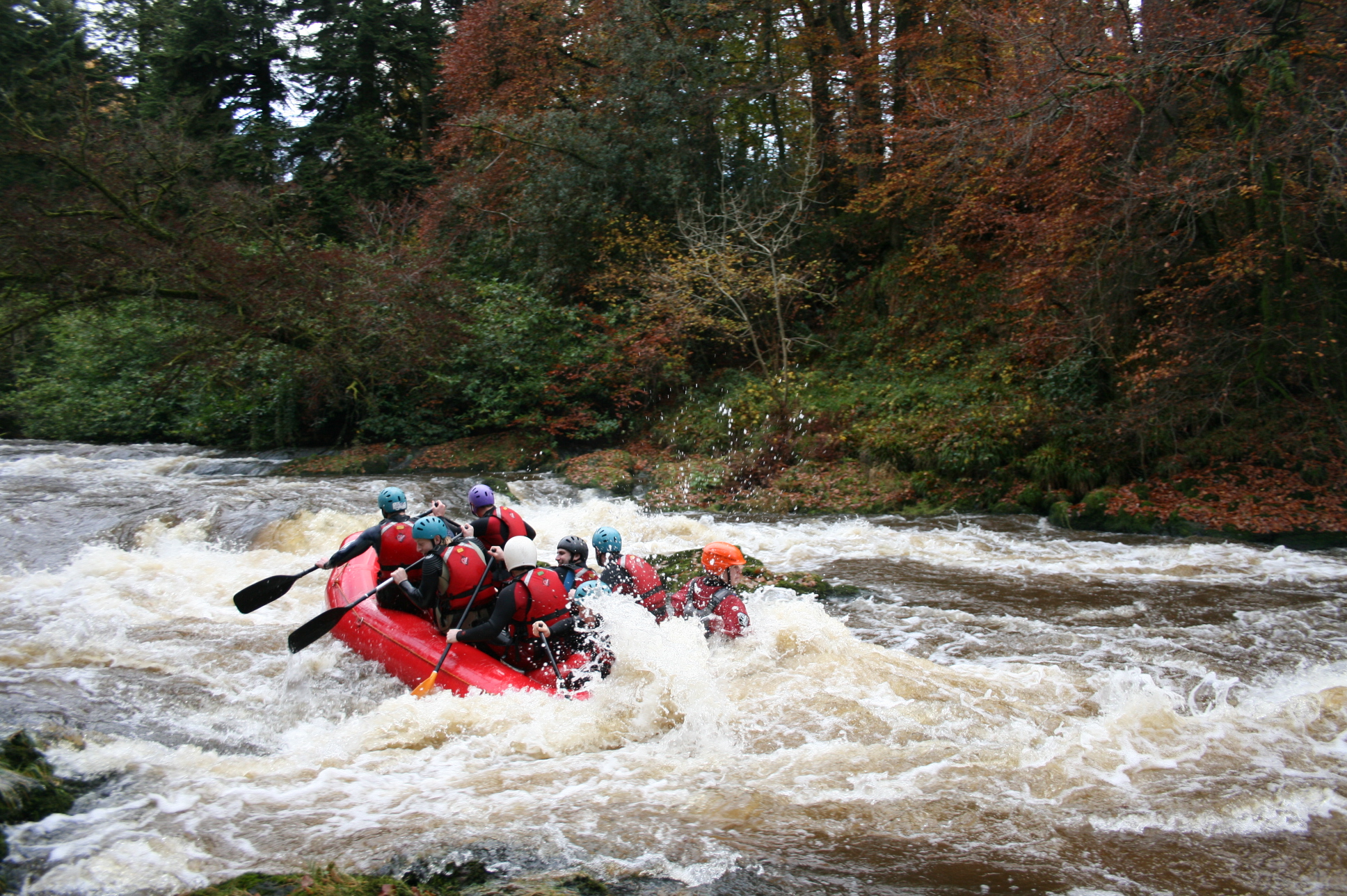 People enjoying white water rafting in Wales