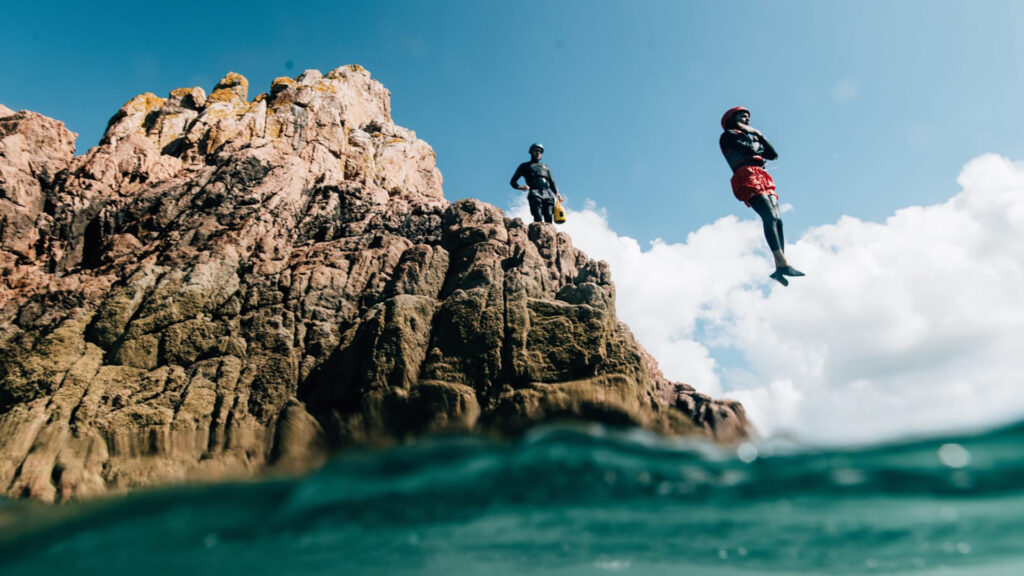 Coasteering adventure in Wales where people are jumping in water