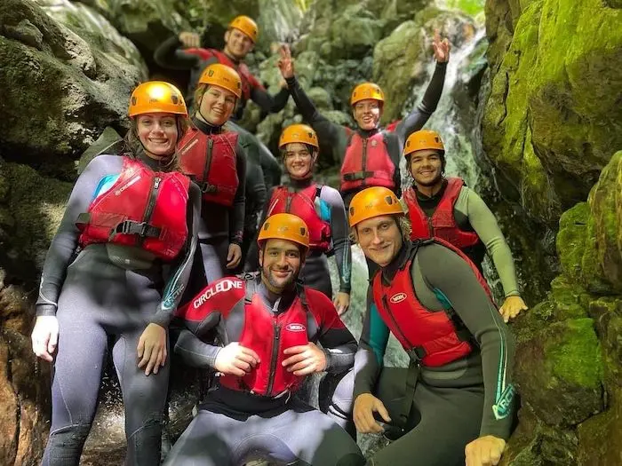 Group of people doing gorge walking team building activity.