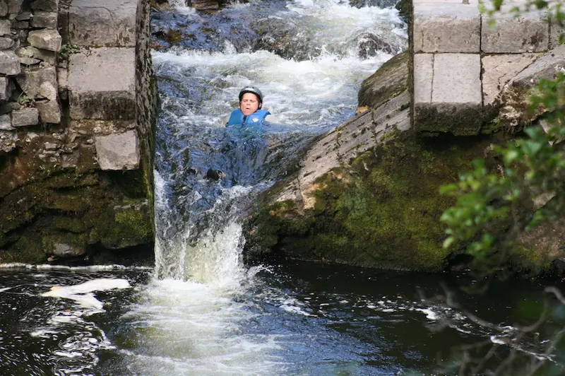 person sliding down a small waterfall