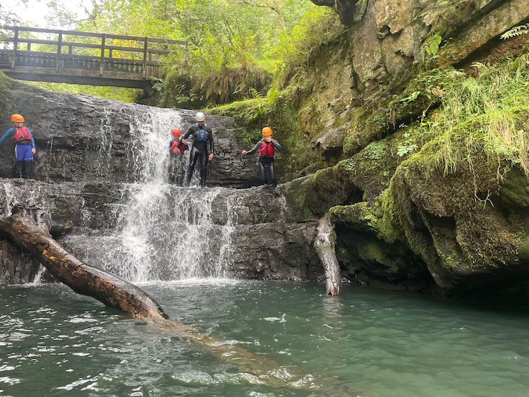 children jumping into water during gorge walking trip 