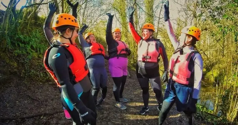 Five women raising hands during their Gorge Walking Hen activity.