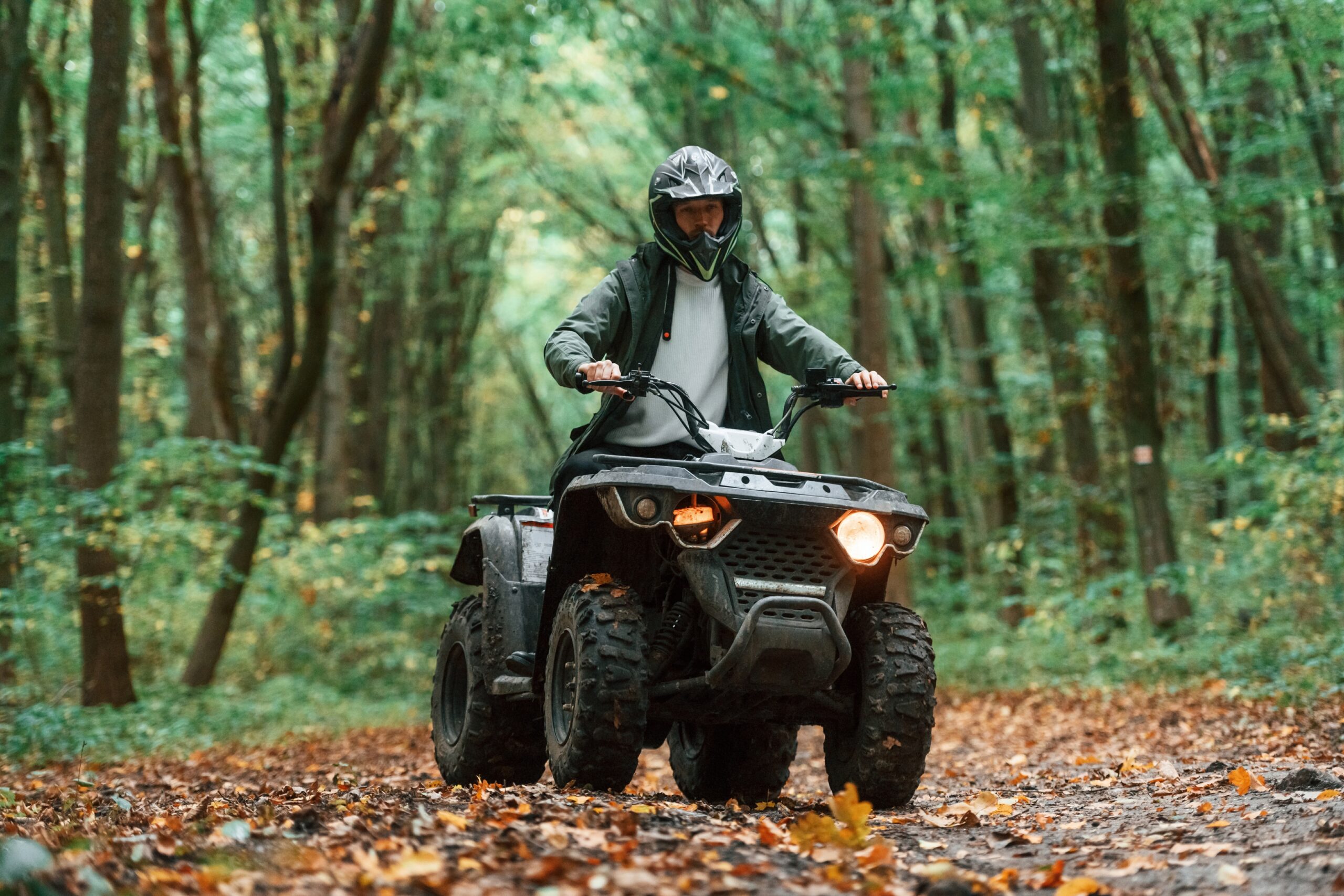A man quad biking in the forest trails of Wales.