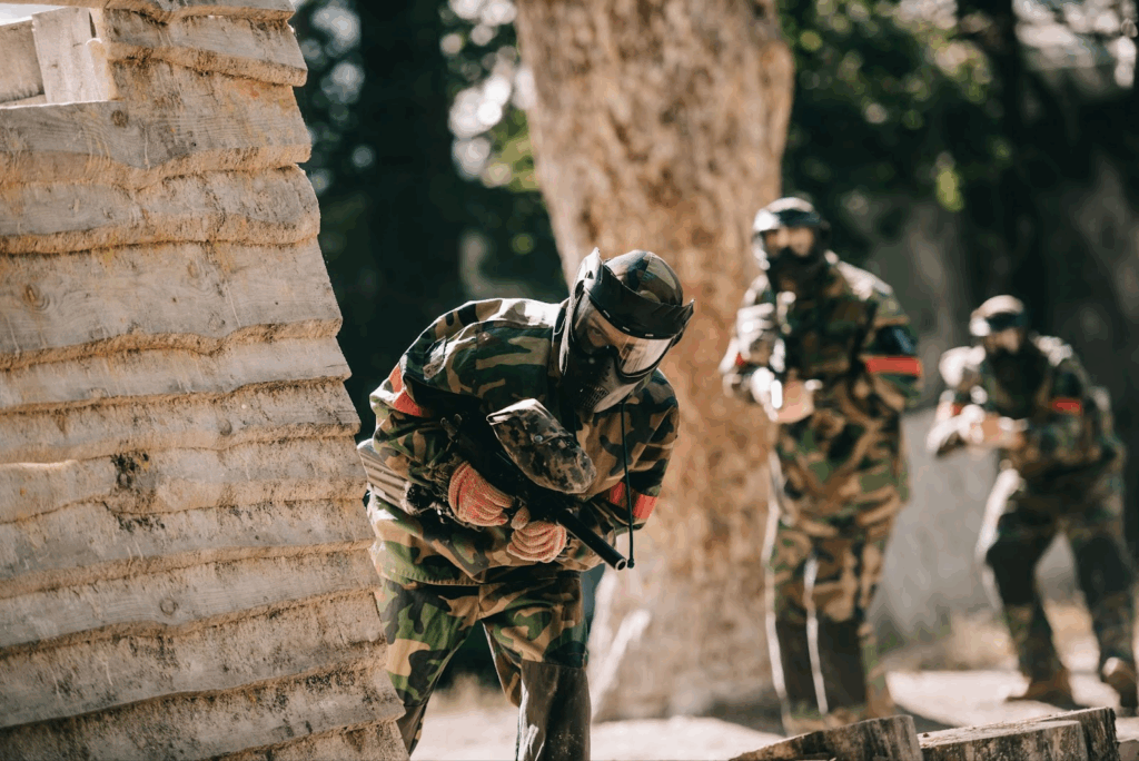 A person paintballing in South Wales wearing complete uniform and equipment taking a defensive position.