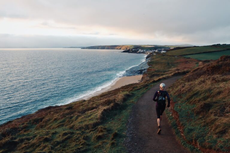 A person walking with the beautiful scenery of Caswell Bay