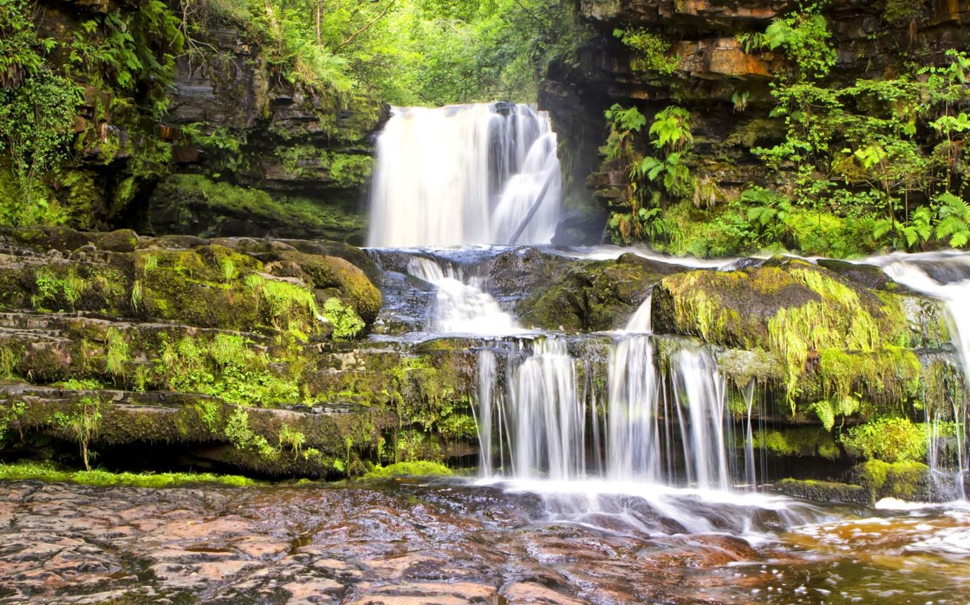 Majestic scenery of a waterfall that is part of the popular "Four Waterfalls Walk" trail near Ystradfellte, Wales.