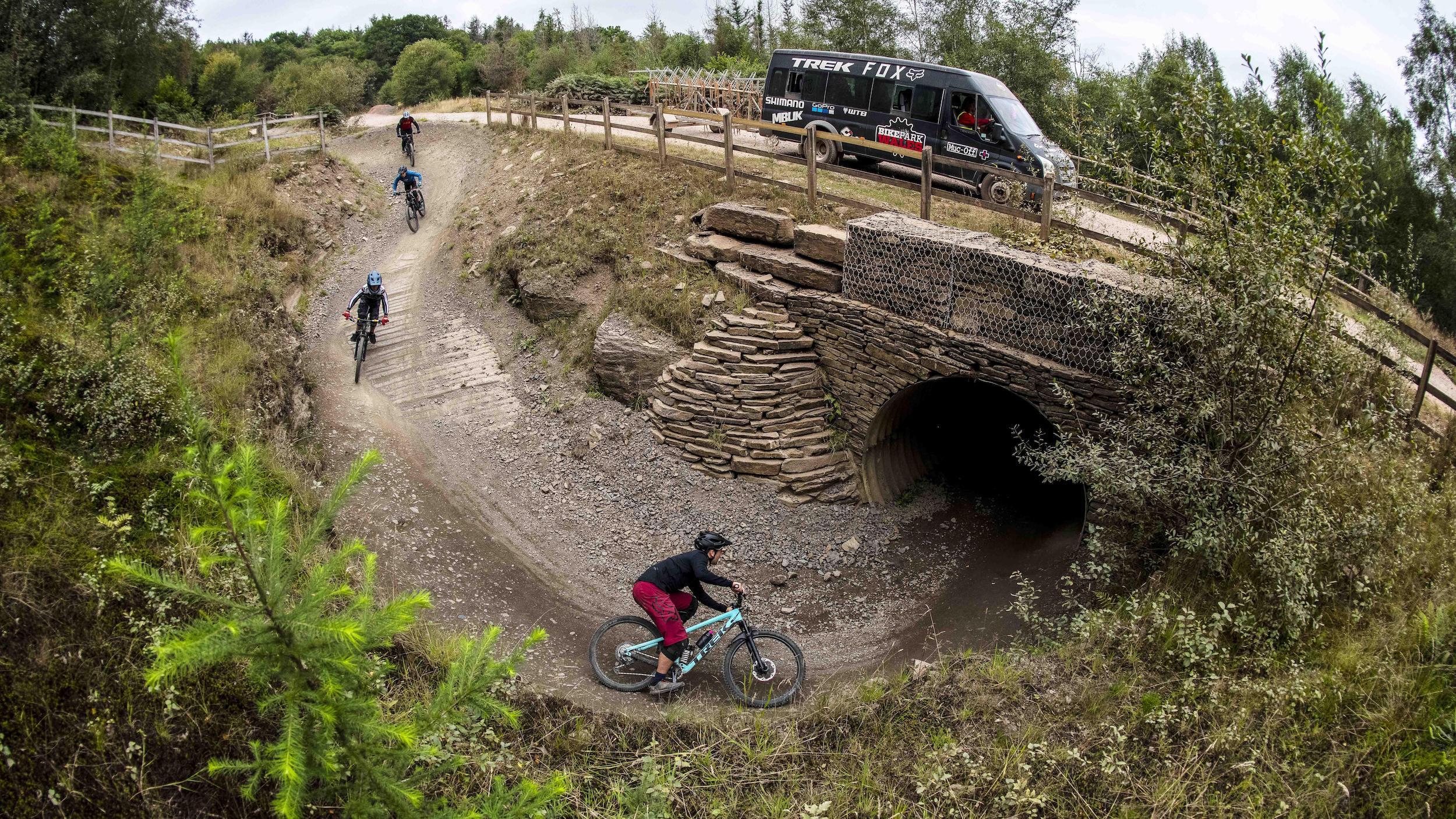 Four people biking on a track at a bike park in Wales
