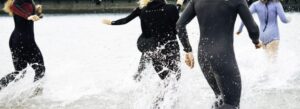 A group of people wearing wetsuit and enjoying the splashes of water