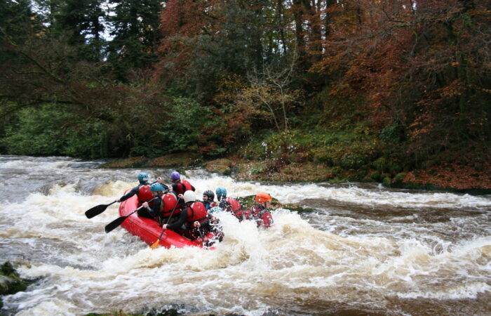 People enjoying white water rafting in Wales