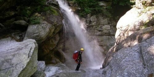 A person posing for a photo in front of a waterfall in France
