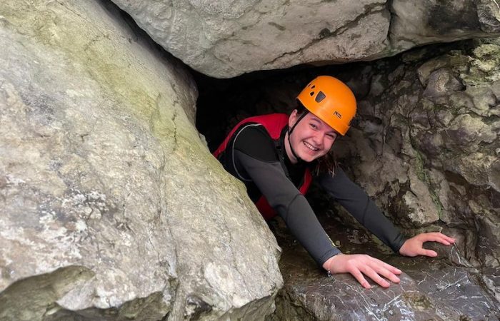 person crawling between rocks