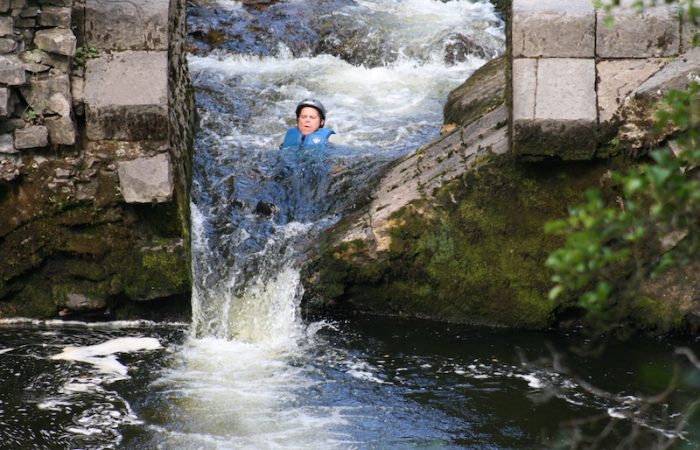 person sliding down a small waterfall